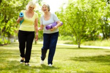 Two women walking with yoga mats